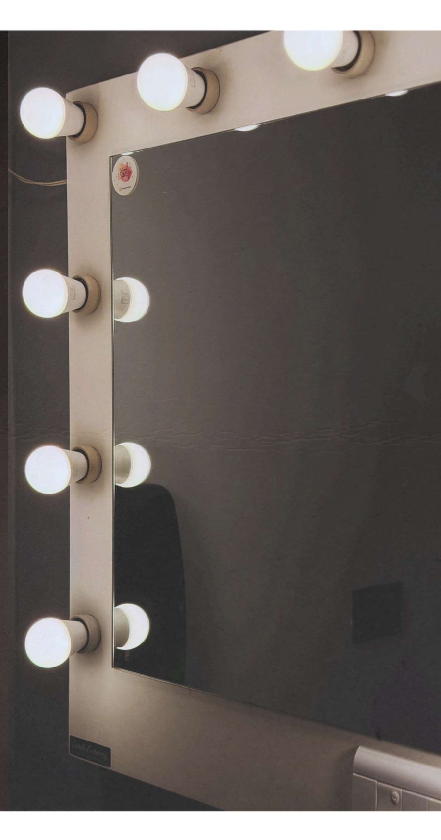 Puesto de maquillaje con espejo y luces de camarín