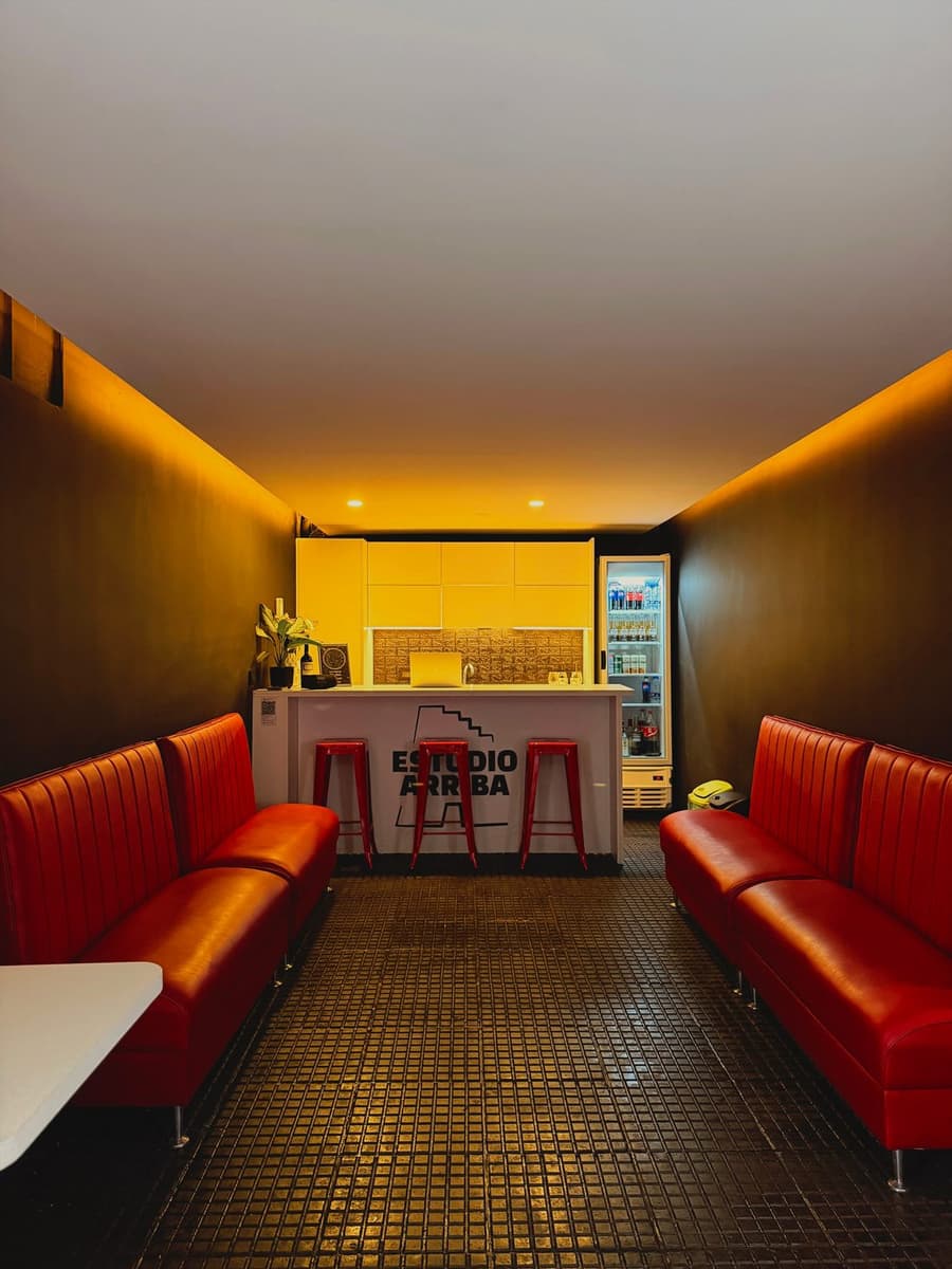 Lounge de recepción y bar de Teatro Arriba con sillones rojos