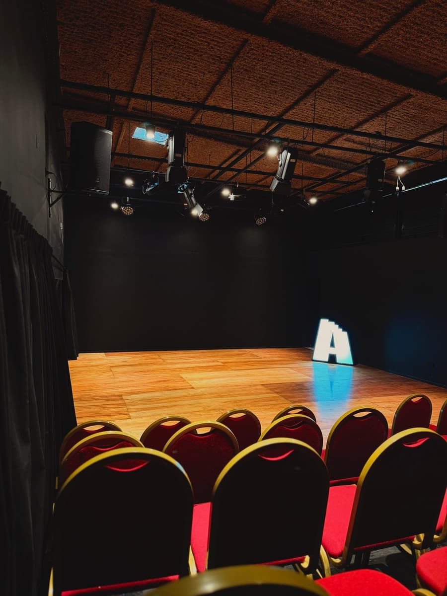 Escenario de la sala teatral con butacas y letra A iluminada